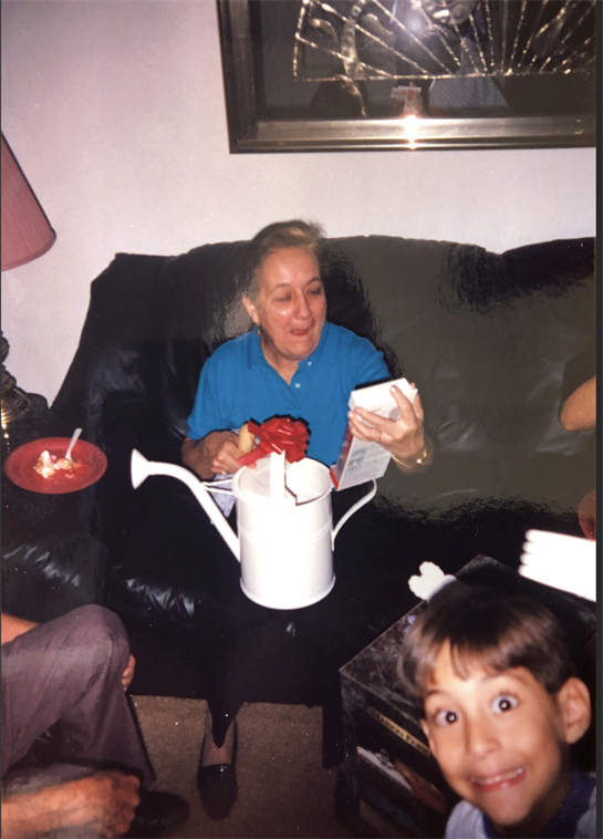 Family members enjoy a birthday celebration in a cozy living room, sharing laughter and gifts.