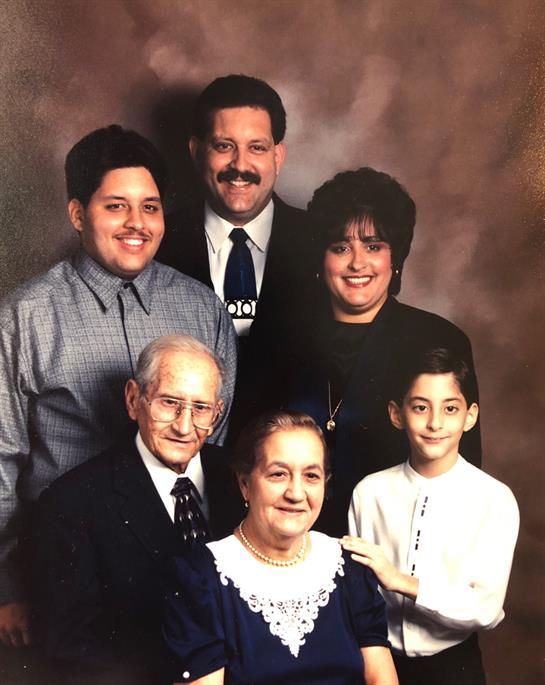 A family gathers in a studio for a portrait, showcasing love and connection across generations.