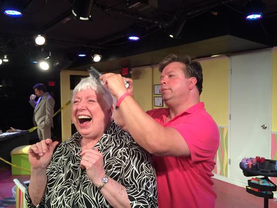 A performer engages with an audience member, creating a joyful and humorous moment on stage.