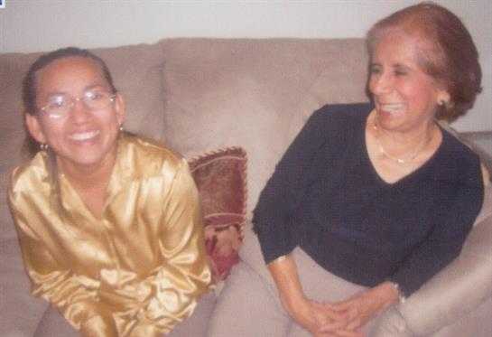 Two family members share a joyful moment on a couch while relaxing in a living space.
