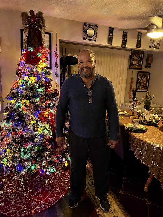 Family gathers around a beautifully lit Christmas tree, enjoying a festive dinner together.