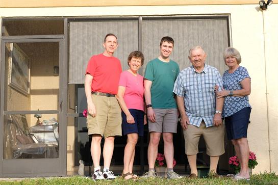 Friends gather outdoors in bright clothing, enjoying their time together on a sunny day.