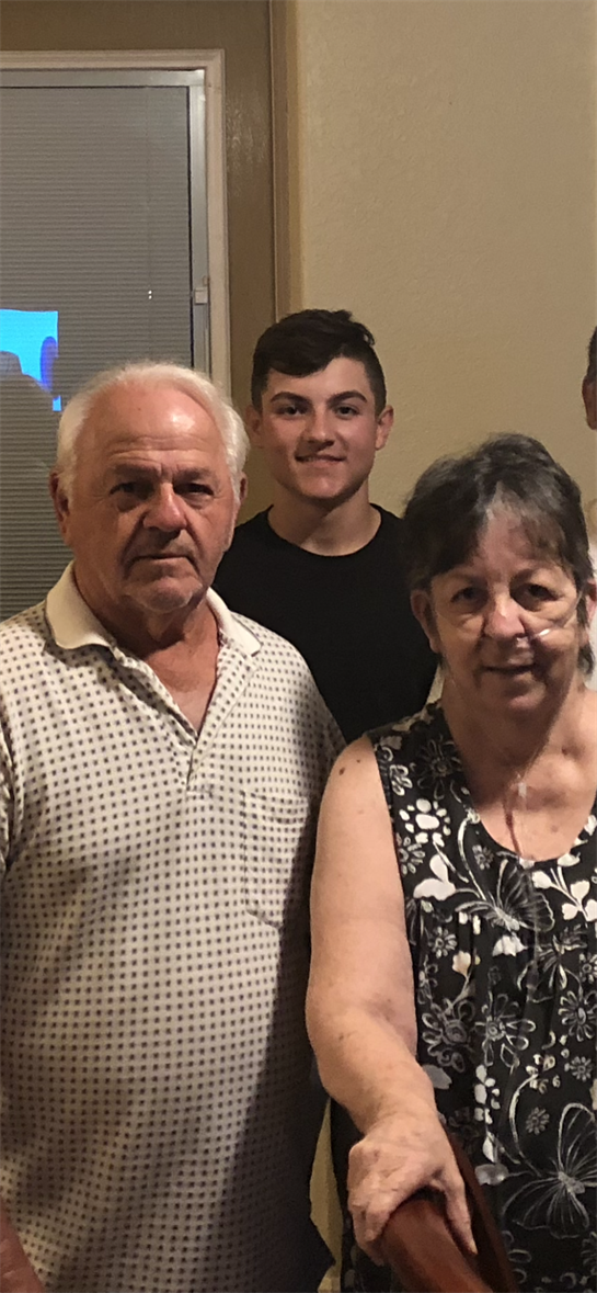 Grandparents proudly gather with family in their living room, making cherished memories.