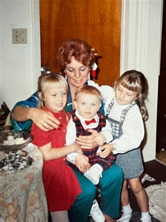A joyful moment shared among a woman and three children celebrating together in a cozy home.