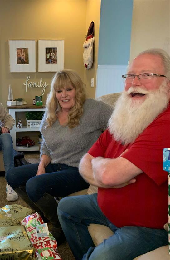 Friends enjoy each other's company in a warm living room setting with festive decorations.