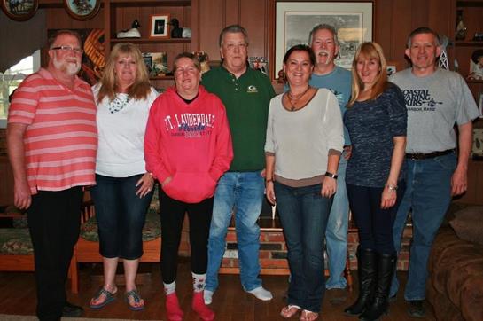 Friends stand together, enjoying each other's company in a warm, inviting living room.