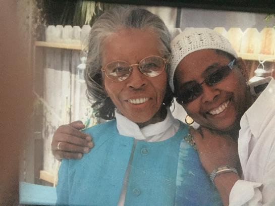 Two women smile warmly at the camera, enjoying a delightful day outdoors together.