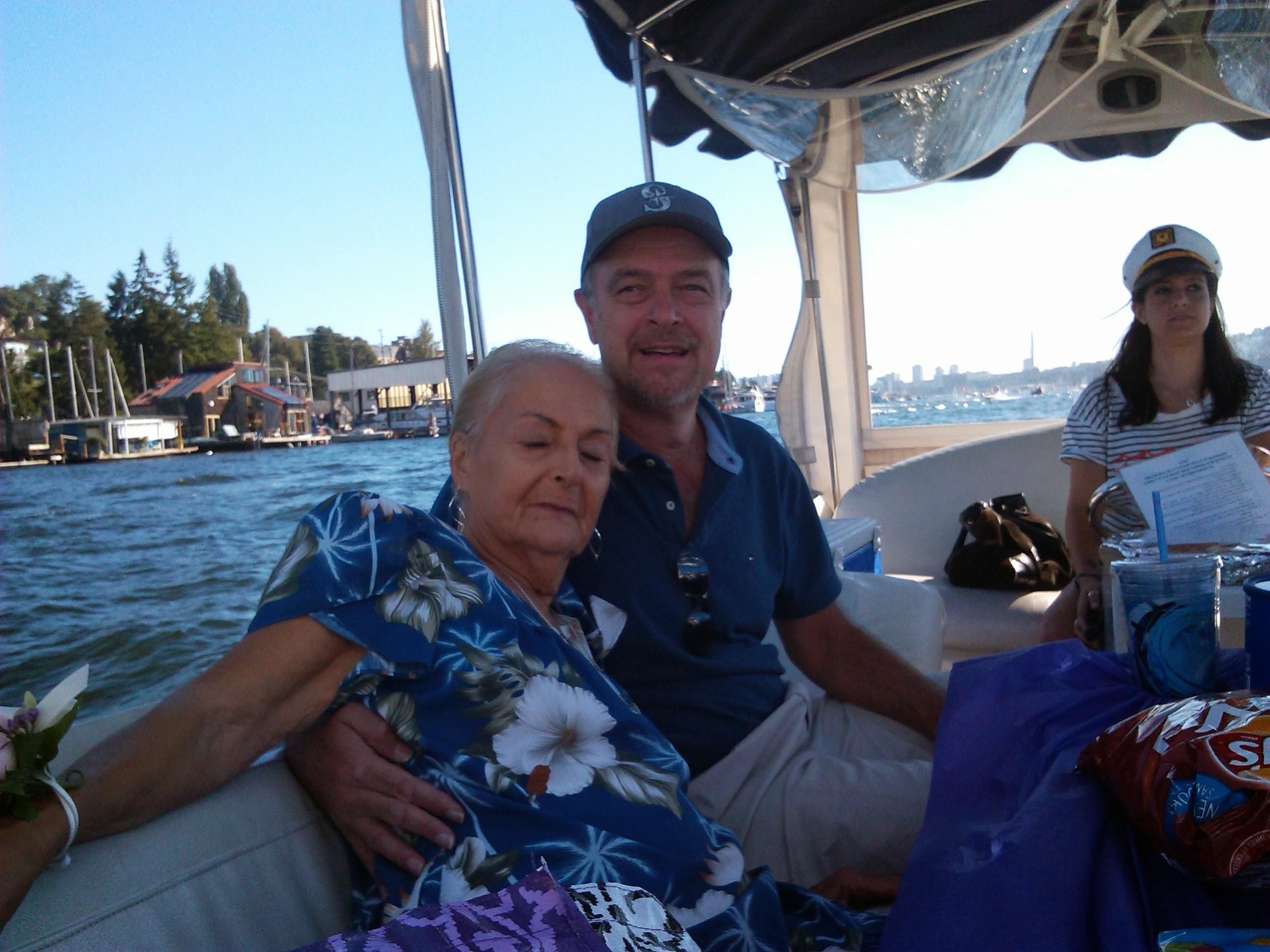 A relaxed family moment on a boat, enjoying the sunny weather and scenic waterfront view.