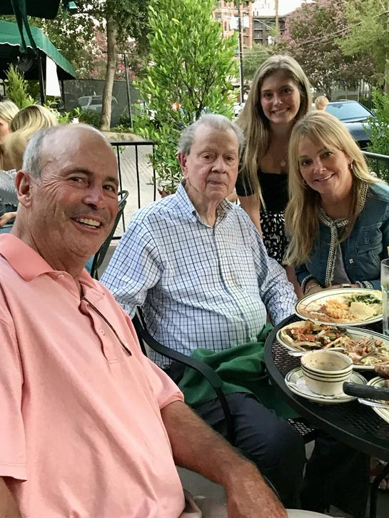 A joyful family enjoys a meal together outside, sharing laughter and delicious dishes.