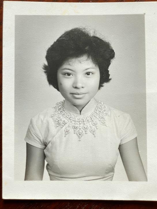 A young woman poses confidently in traditional attire, highlighting her beauty and poise.