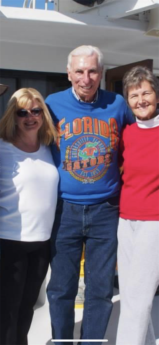Friends and family smile together outdoors in casual wear on a sunny day.
