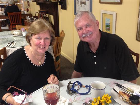 A happy couple enjoys a meal together at a lovely restaurant, chatting joyfully.
