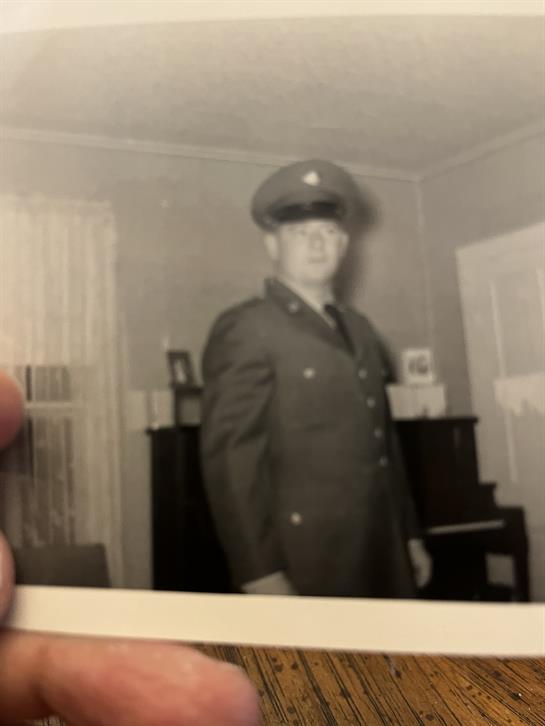 A soldier in a military uniform stands confidently indoors, showcasing pride and history.