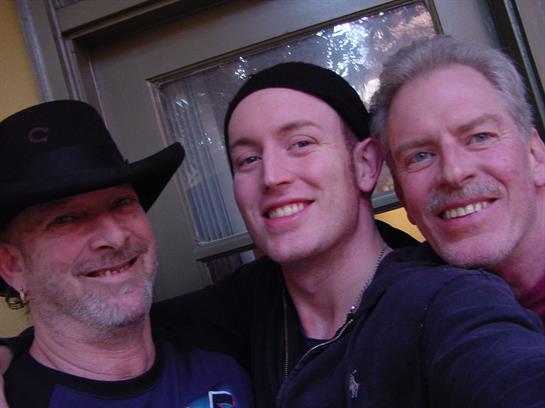 Friends smile and pose together for a selfie in a cozy indoor setting, celebrating their time.