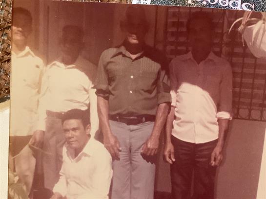 Several men pose together outside a building, showcasing camaraderie and community spirit.