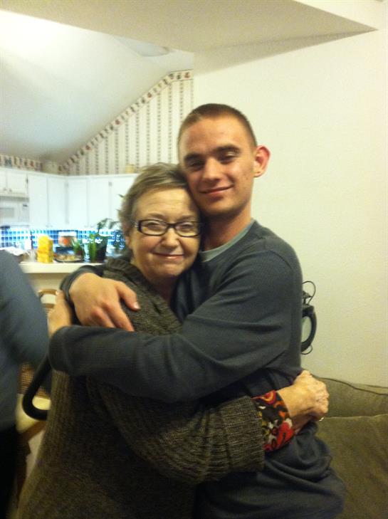 Two family members share a heartfelt hug, celebrating a joyful moment in a comfortable living space.