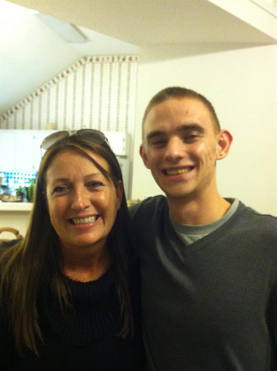 Two individuals share a warm smile in a comfortable indoor environment, radiating happiness.