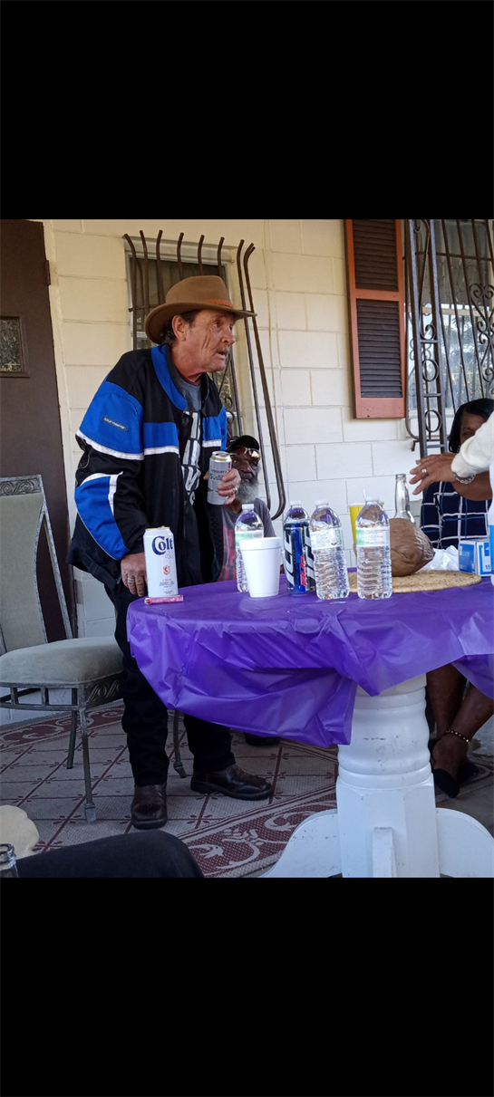 Guests enjoy drinks and socialize around a colorful table during a lively afternoon gathering.