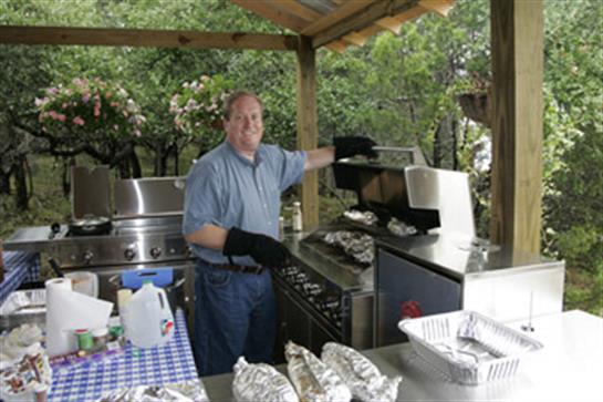 Chef is grilling food outdoors, showcasing skills in a relaxed and friendly atmosphere.