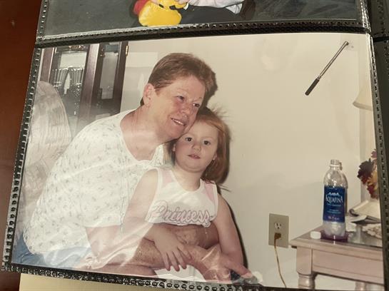 A grandmother embraces her granddaughter, sharing smiles and joy in a warm living space.