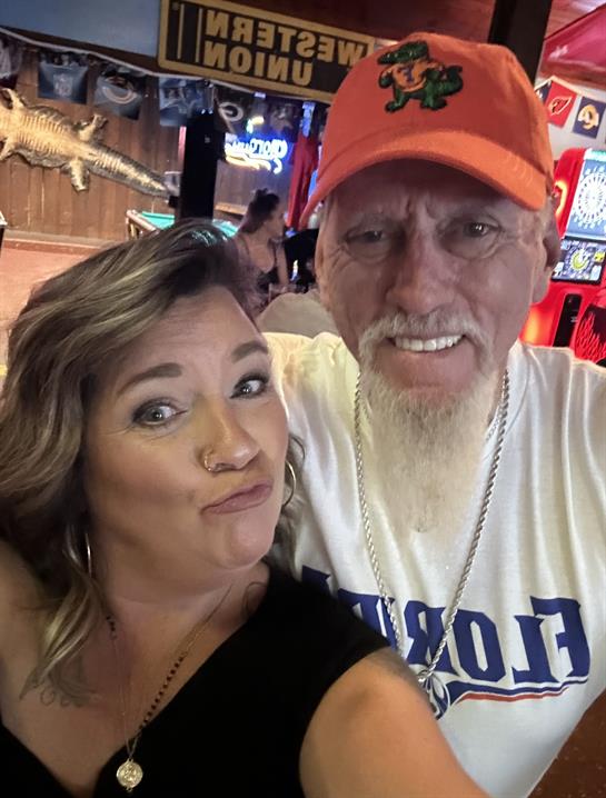 Two smiling individuals share a fun moment at a vibrant gathering, enjoying their time in the venue.