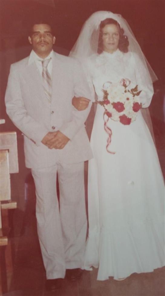 Elegant couple stands happily together, surrounded by decorations on their wedding day.