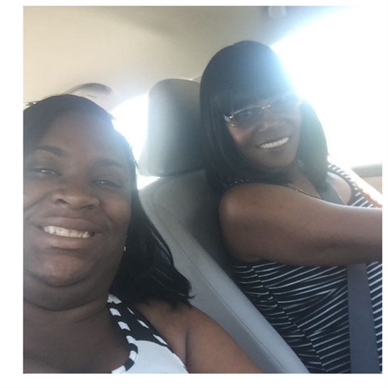Two friends share a joyful moment while driving on a sunny day, capturing friendship and happiness.