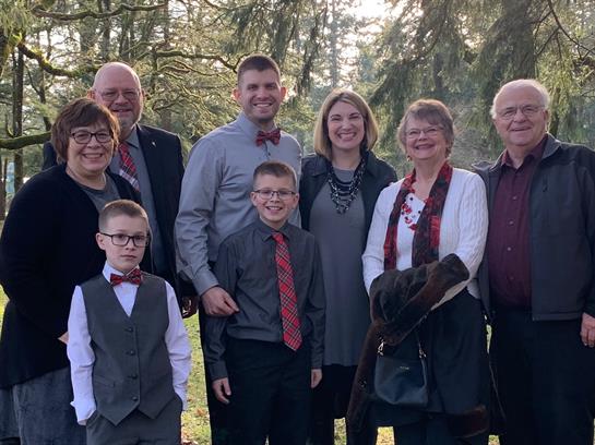 Family members smiling together in a park, enjoying a sunny day and celebrating.
