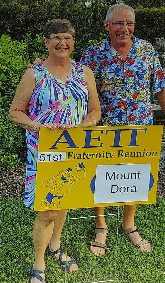 Participants gather for a lively fraternity reunion in Mount Dora holding a colorful sign.