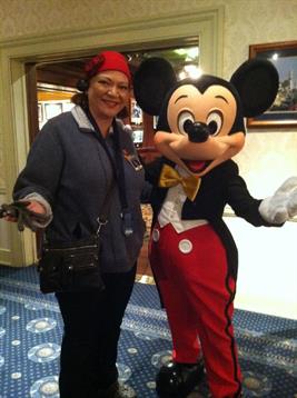 A visitor enjoys a fun interaction with a beloved cartoon character indoors at a vibrant venue.