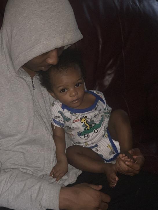 A father and child share a quiet moment together, highlighting their bond in an intimate atmosphere.