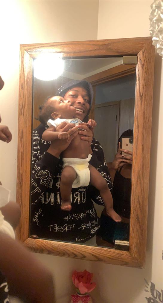 Father and baby share a joyful moment in front of the mirror, capturing their playful bond.