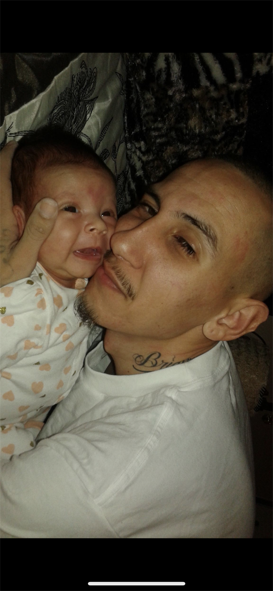 A father playfully interacts with his baby, showcasing their bonding in a warm environment.