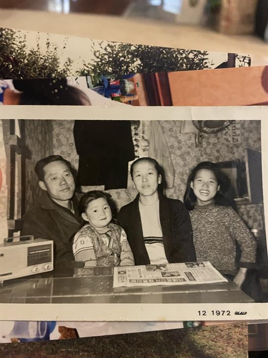 A joyful family stands together in a warm indoor environment, reflecting love and unity.