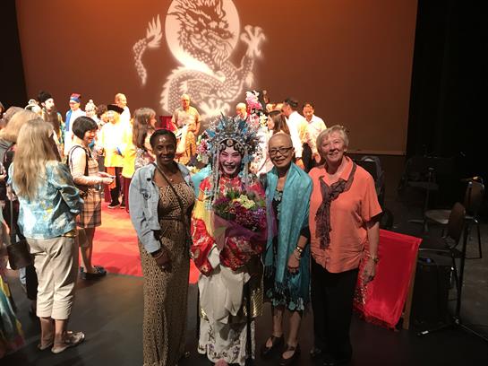 A lively celebration with performers in vibrant costumes and an engaged audience.