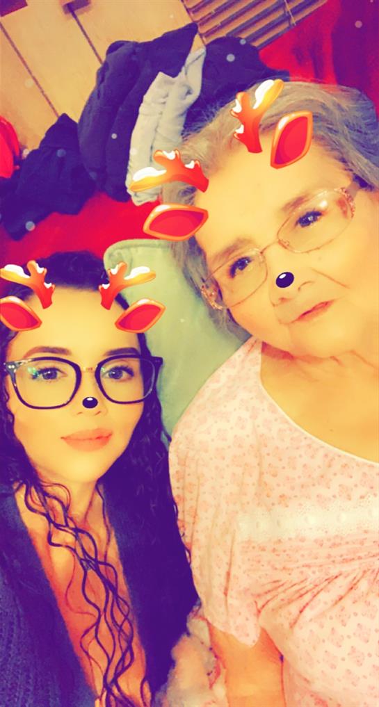 Two family members pose happily with reindeer filters, enjoying quality time during the holidays.