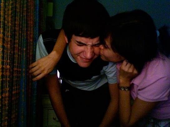 Close friends enjoy a lighthearted interaction in a warm, intimate setting while laughing.