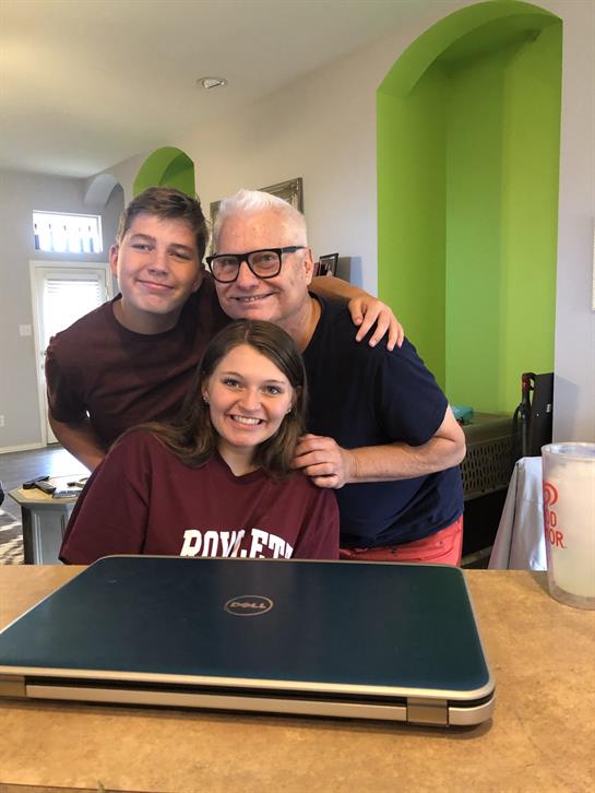 Family members pose happily together in a cozy home, enjoying each other's company and laughter.