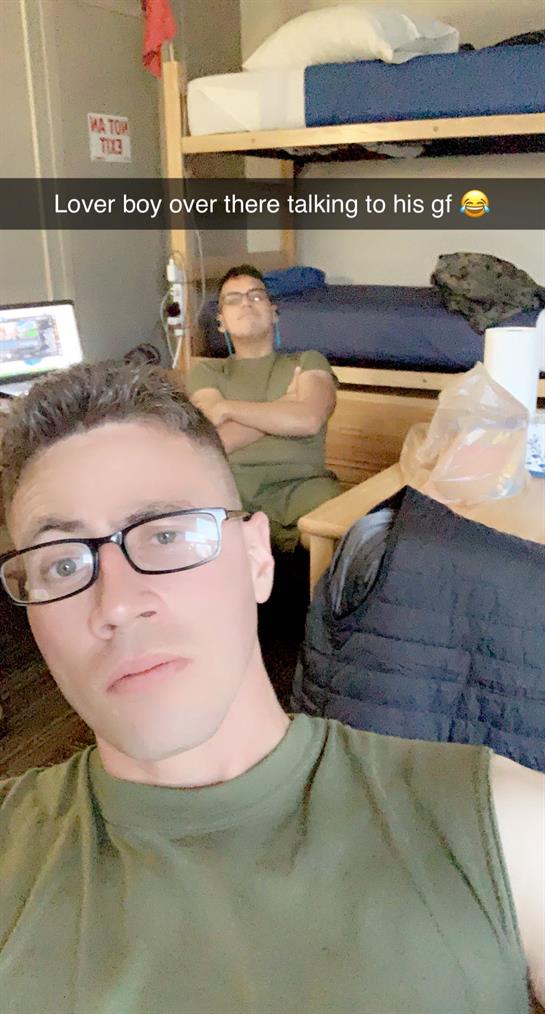 Two friends enjoy a laid-back afternoon in their dorm room, surrounded by personal items.