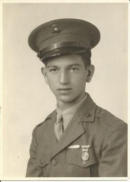 A young man dressed in a military uniform poses for a portrait with a serious expression.