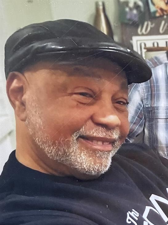 A cheerful elderly man in a cap shares joyful moments with friends in a lively setting.