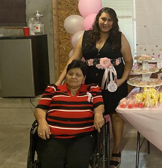 A woman in a wheelchair with a woman in a room with balloons