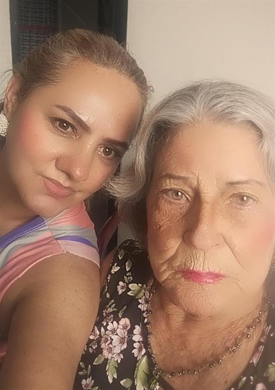 Two women pose for a selfie, expressing joy and warmth while showcasing their bond.