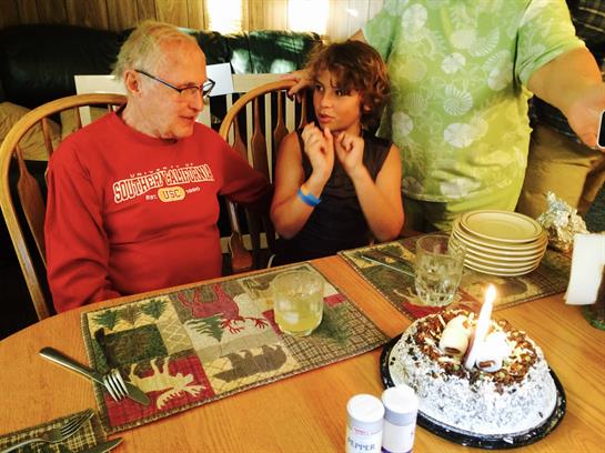 A man and woman sitting at a table with a cake