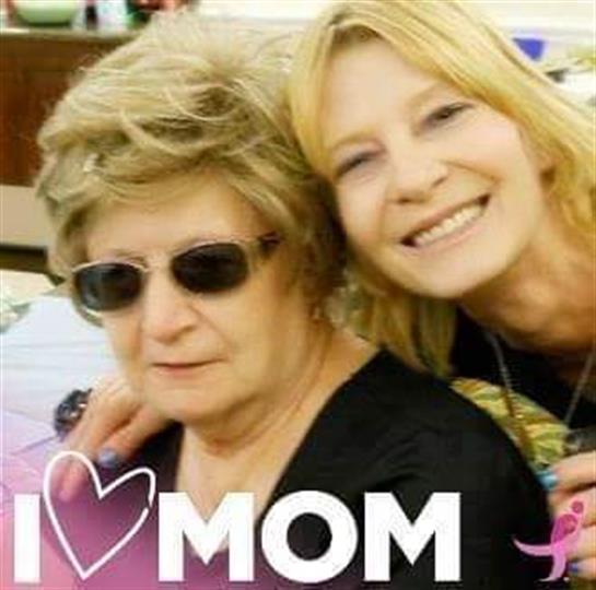 A woman takes a smiling selfie with her mother, showcasing their close bond during a celebration.