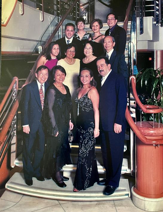 Friends dressed in formal attire gather on a staircase for a memorable evening aboard a cruise ship.