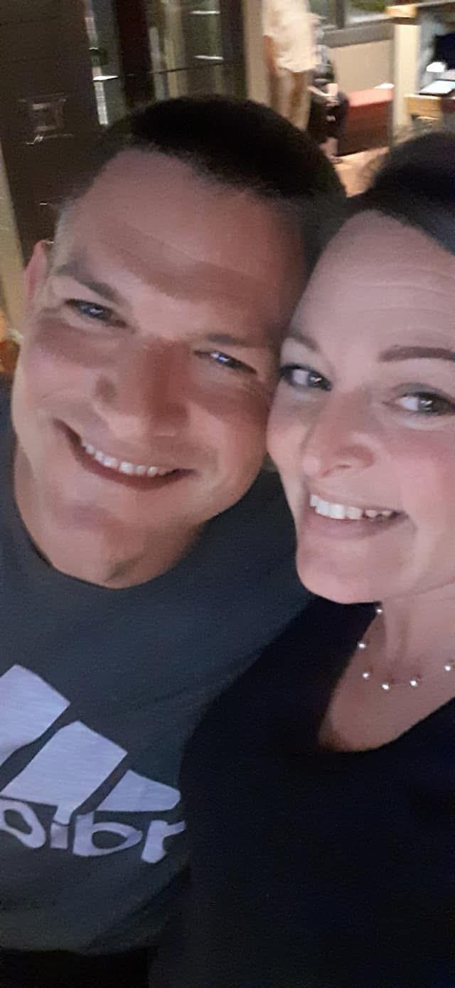 A happy couple enjoys each other's company at a social gathering with friends.