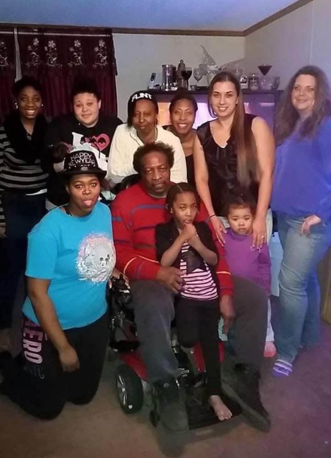 A diverse group of family members enjoys each other's company in a warm living room.