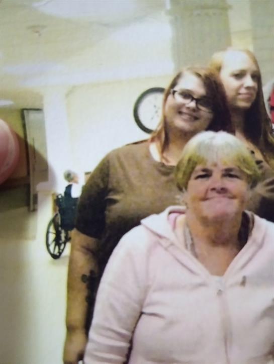 Four friends smile together in a warm, inviting living room filled with personal touches.