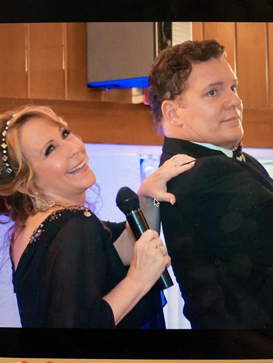 A woman holding a microphone next to a man